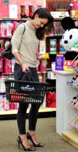 Woman buying a toy with a black shopping basket.