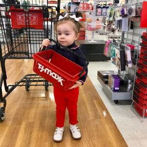 Little girl holding a red TJ Maxx shopping basket.