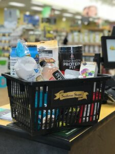 Black shopping basket with groceries in it.
