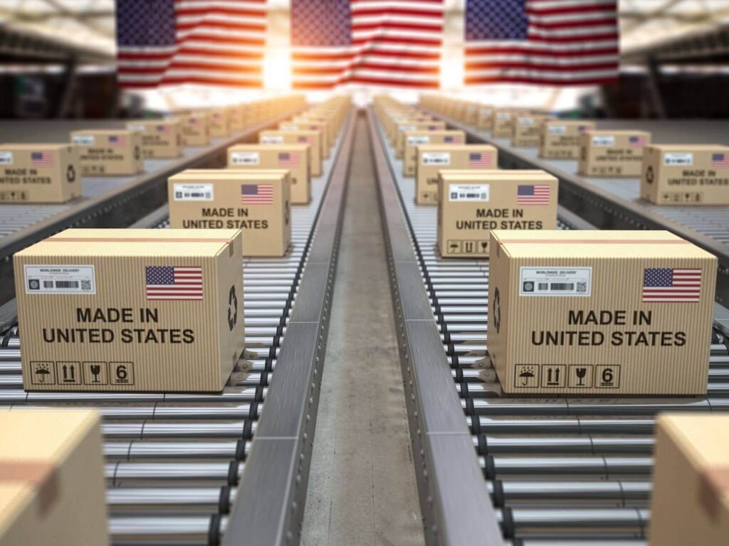 Cardboard boxes labeled "Made in United States" with American flags on a conveyor belt.