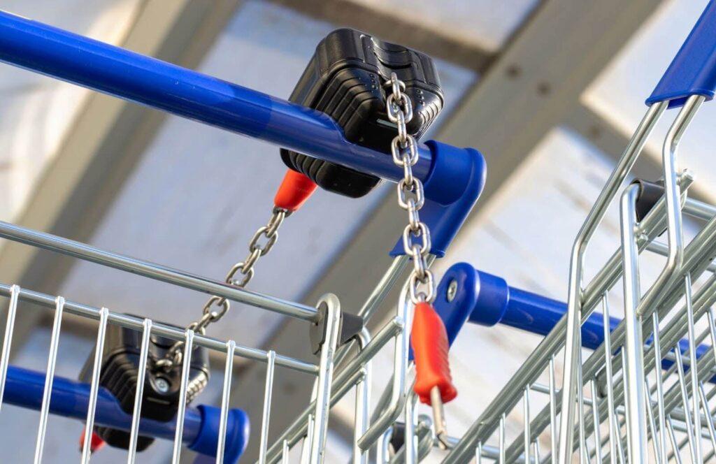 A closeup of connected shopping carts with blue handles.