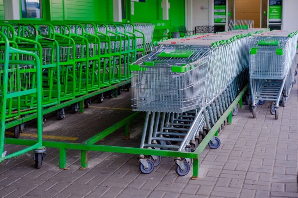 A row of empty shopping carts outside a store.