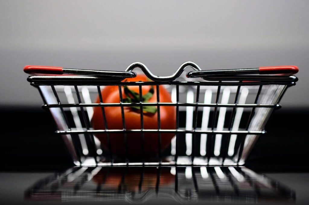 Tomato in a mini shopping basket.