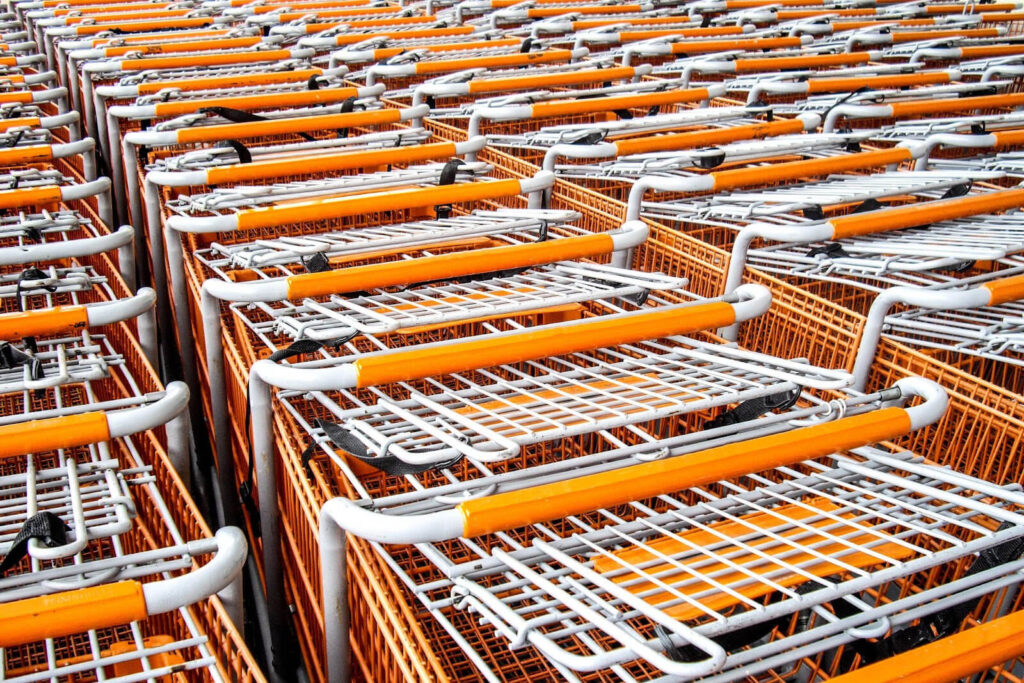 Multiple white and orange shopping carts arranged in rows.