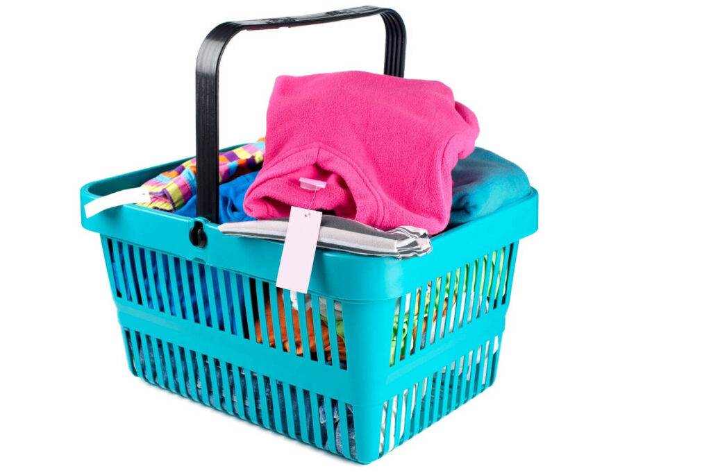 Colorful clothes in a turquoise shopping basket.