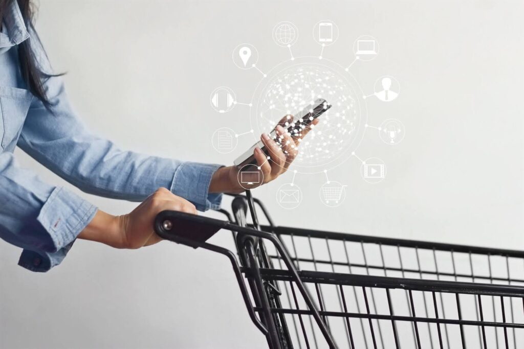 Man on his phone with a shopping cart.