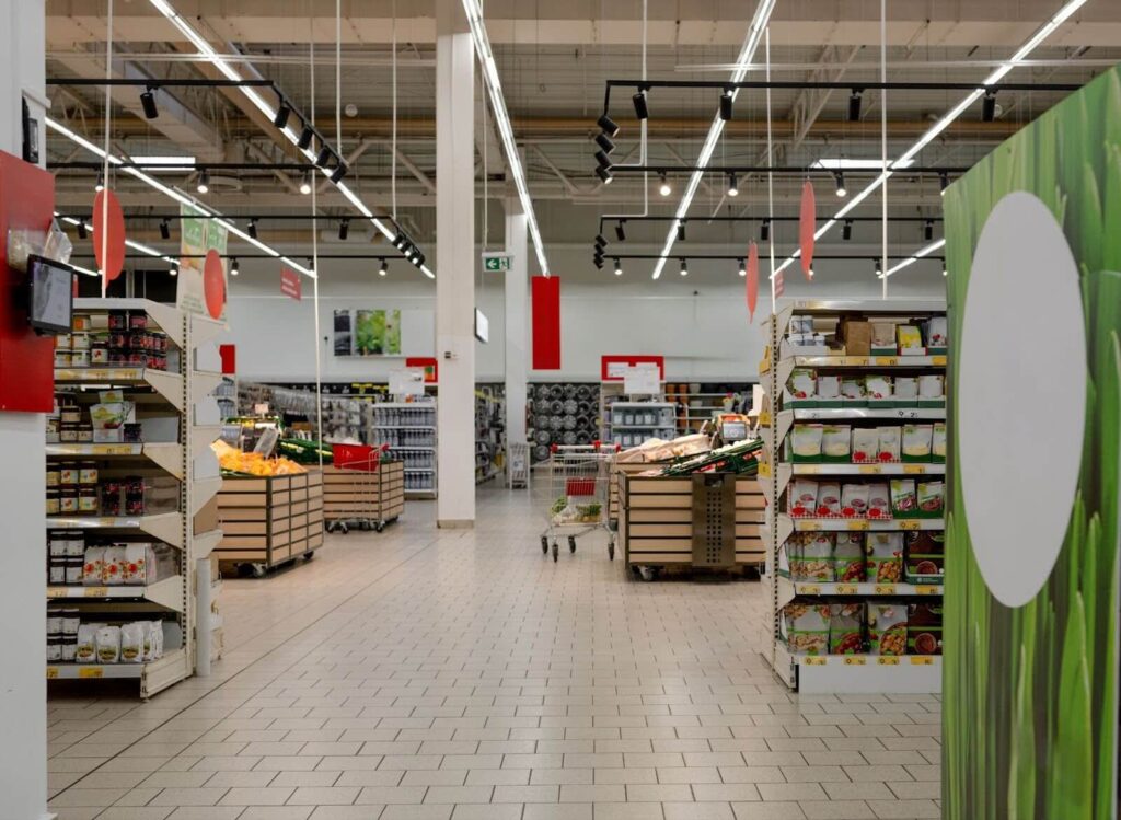 Bright supermarket interior with full shelves.