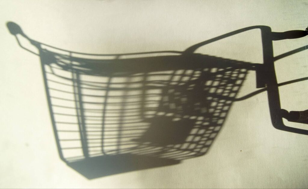 A shopping cart shadow on a white wall.