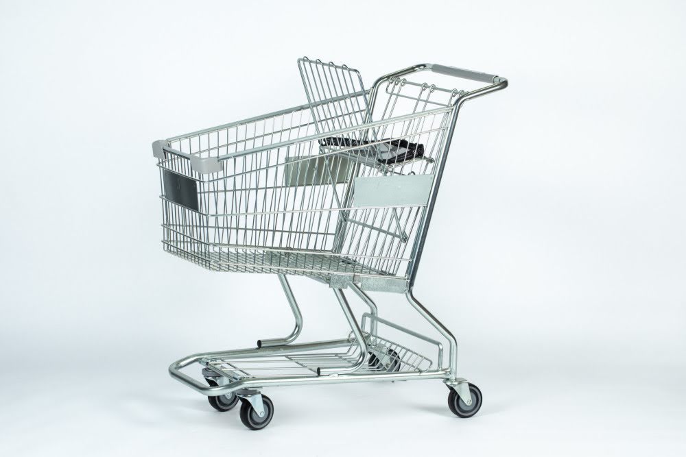 An empty shopping cart with handle, wire basket, child seat and four wheels on a white background.